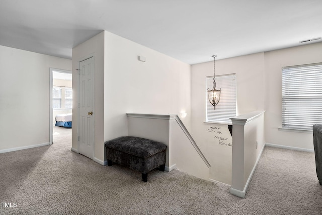 stairs featuring carpet flooring and a chandelier