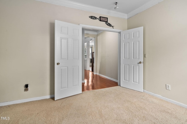 empty room featuring carpet flooring and ornamental molding