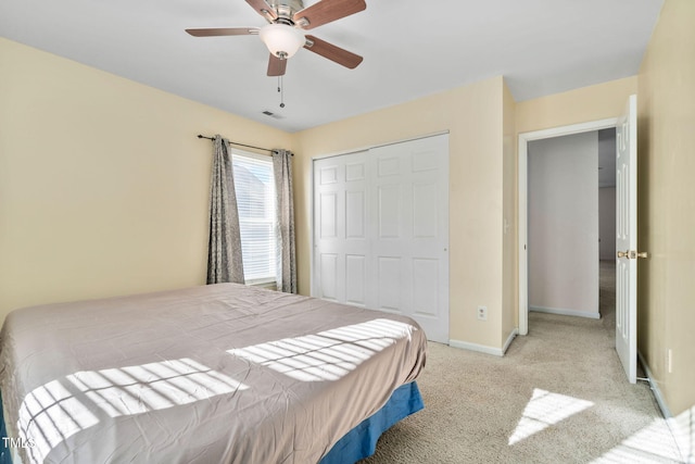 carpeted bedroom featuring a closet and ceiling fan