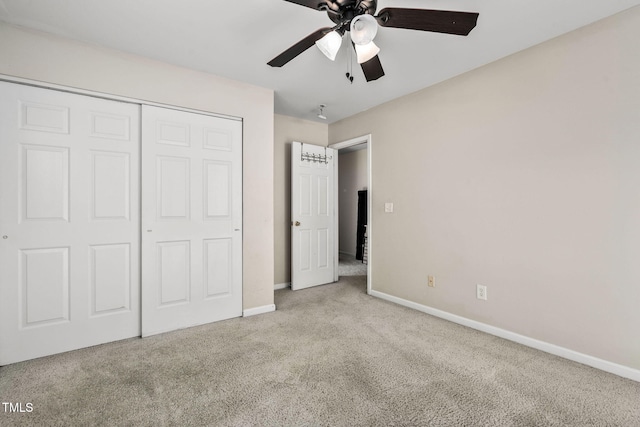 unfurnished bedroom with ceiling fan, a closet, and light carpet