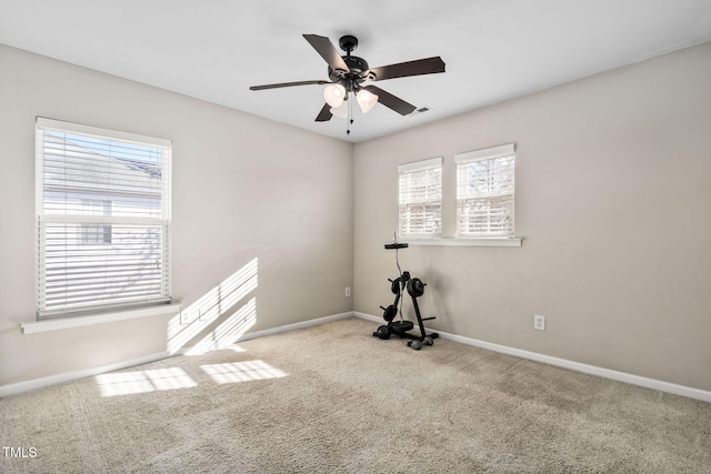 carpeted spare room featuring ceiling fan