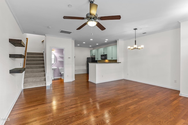 unfurnished living room featuring ornamental molding, dark wood-type flooring, and ceiling fan with notable chandelier