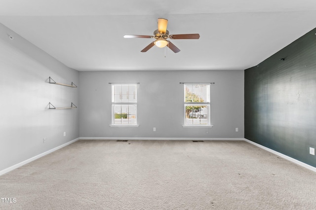 carpeted spare room with ceiling fan