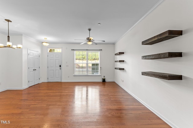 unfurnished living room featuring crown molding, wood-type flooring, and ceiling fan with notable chandelier