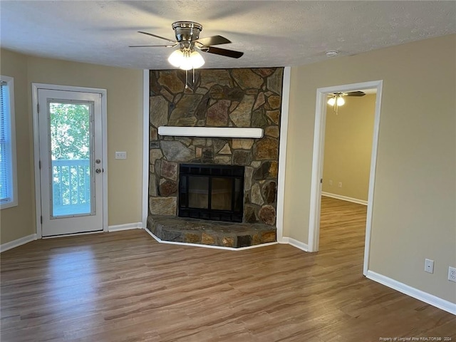 unfurnished living room featuring wood-type flooring, a textured ceiling, and a fireplace