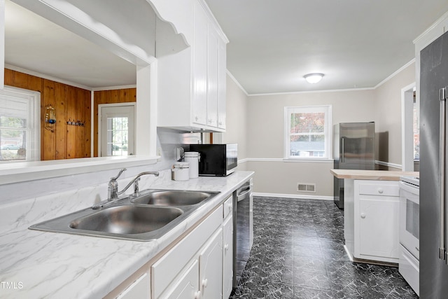 kitchen with stainless steel appliances, white cabinetry, sink, and ornamental molding