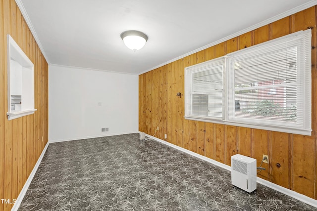 empty room with wood walls and crown molding