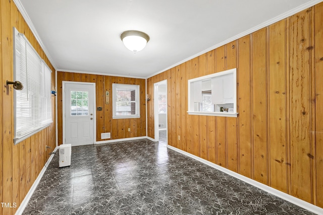 foyer with wood walls and crown molding