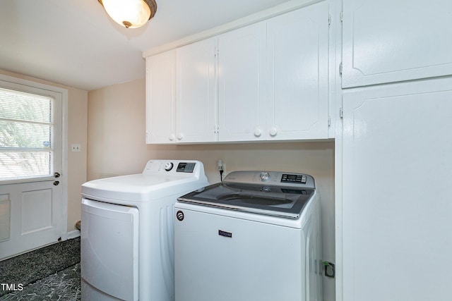 laundry room with washing machine and dryer and cabinets