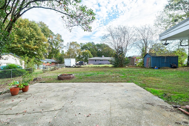 view of patio / terrace with a fire pit and a storage unit