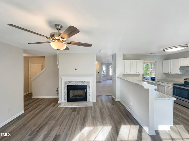 kitchen featuring stainless steel range with electric cooktop, dark hardwood / wood-style flooring, kitchen peninsula, white cabinetry, and ceiling fan