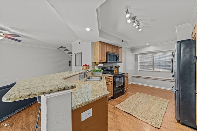 kitchen with black electric range, sink, kitchen peninsula, stainless steel fridge, and light hardwood / wood-style flooring