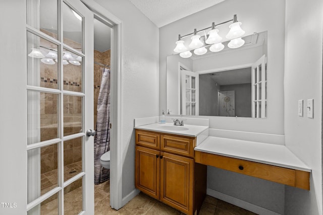 bathroom featuring toilet, tile patterned flooring, curtained shower, vanity, and a textured ceiling