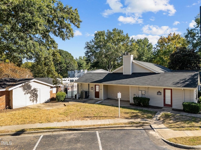 view of front of property featuring central air condition unit and a front lawn