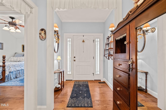 entrance foyer featuring crown molding, light wood-type flooring, and ceiling fan