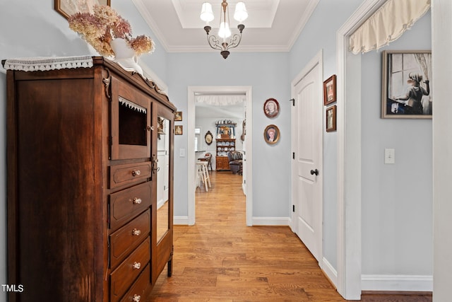 corridor featuring ornamental molding, a chandelier, and light hardwood / wood-style floors