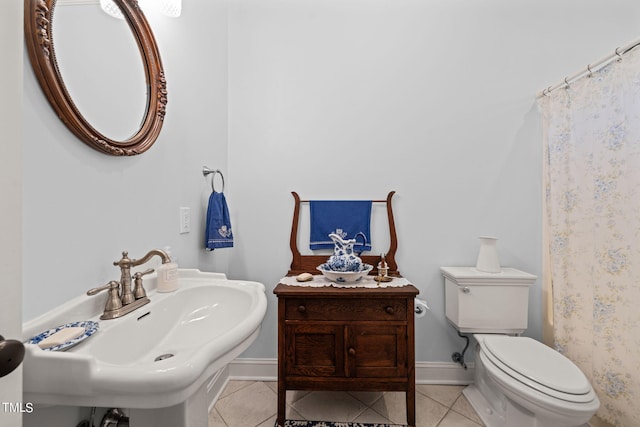 bathroom featuring toilet, sink, and tile patterned flooring