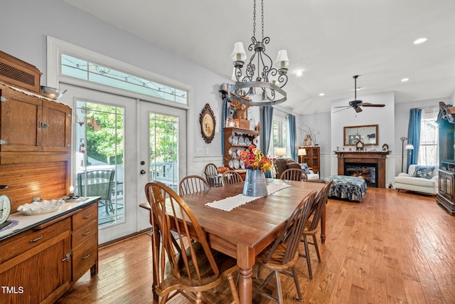 dining space with light hardwood / wood-style floors, french doors, and ceiling fan with notable chandelier