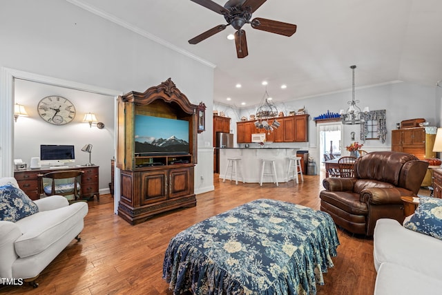 living room featuring crown molding, wood-type flooring, vaulted ceiling, and ceiling fan with notable chandelier