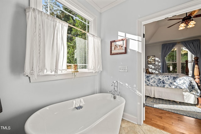 bathroom featuring a tub to relax in, wood-type flooring, ornamental molding, vaulted ceiling, and ceiling fan