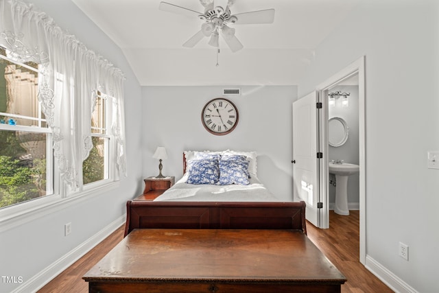 bedroom featuring connected bathroom, vaulted ceiling, hardwood / wood-style flooring, and ceiling fan