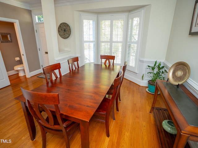 dining space featuring a wealth of natural light, light hardwood / wood-style floors, and crown molding