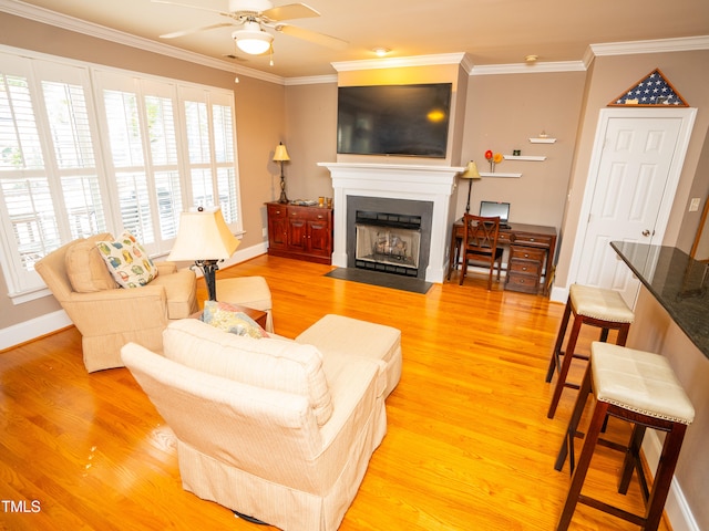 living room with hardwood / wood-style flooring, crown molding, and ceiling fan