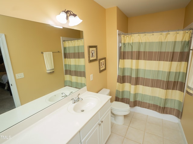 bathroom with toilet, vanity, and tile patterned floors