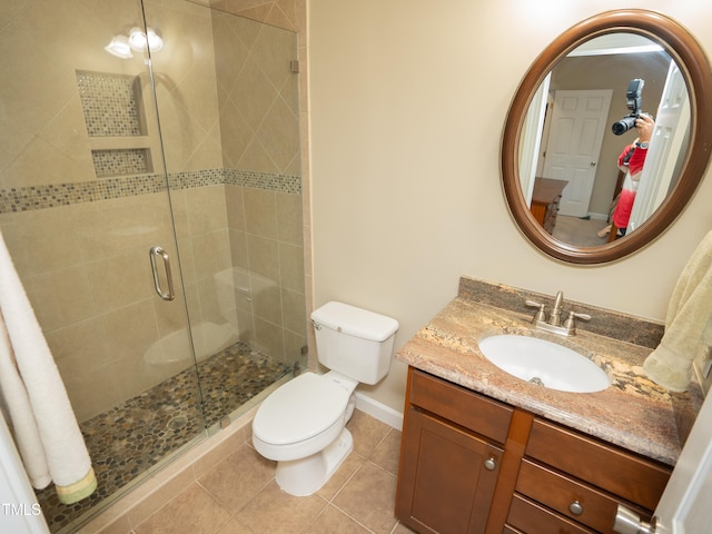 bathroom featuring vanity, walk in shower, tile patterned floors, and toilet