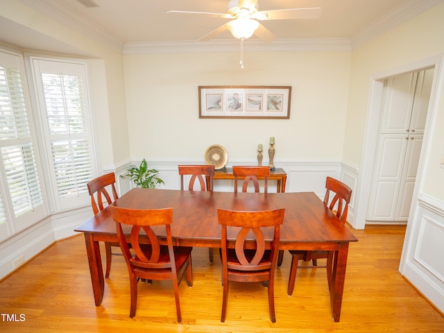 dining area with light wood-type flooring, ceiling fan, and ornamental molding