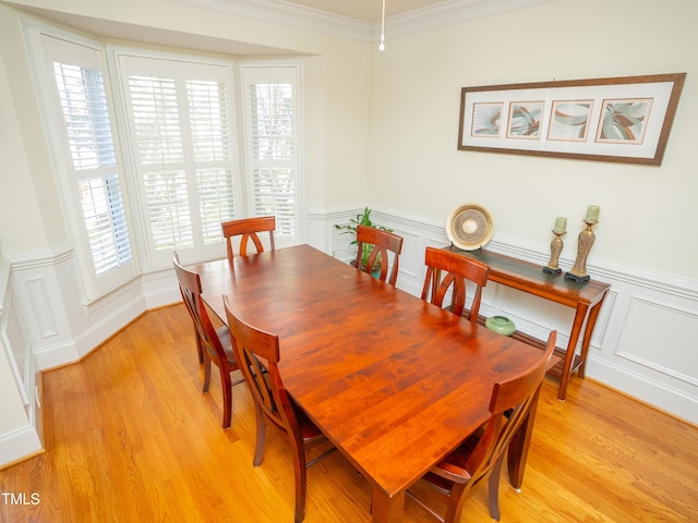 dining room with ornamental molding, light wood-type flooring, and a healthy amount of sunlight