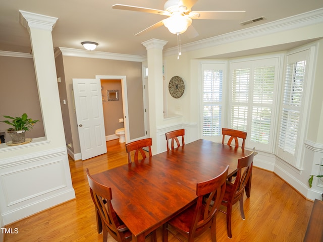 dining room with ornate columns, light wood-type flooring, ceiling fan, and crown molding