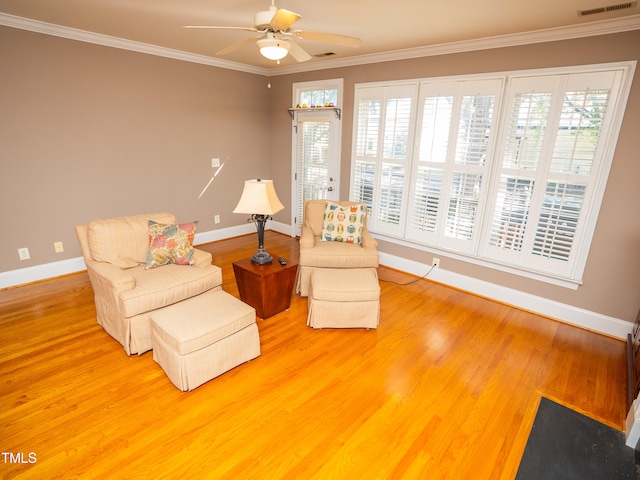 sitting room featuring hardwood / wood-style flooring, ceiling fan, and crown molding