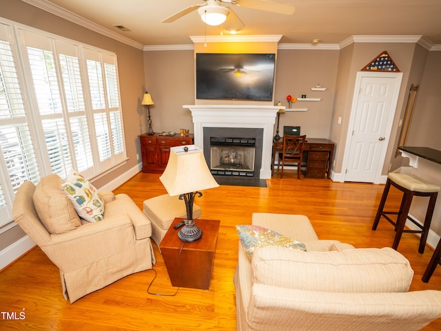 living room featuring ceiling fan, wood-type flooring, and ornamental molding