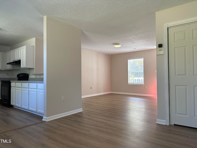 unfurnished living room with a textured ceiling and dark hardwood / wood-style floors