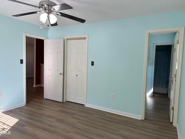 unfurnished bedroom with dark hardwood / wood-style flooring, a closet, a textured ceiling, and ceiling fan