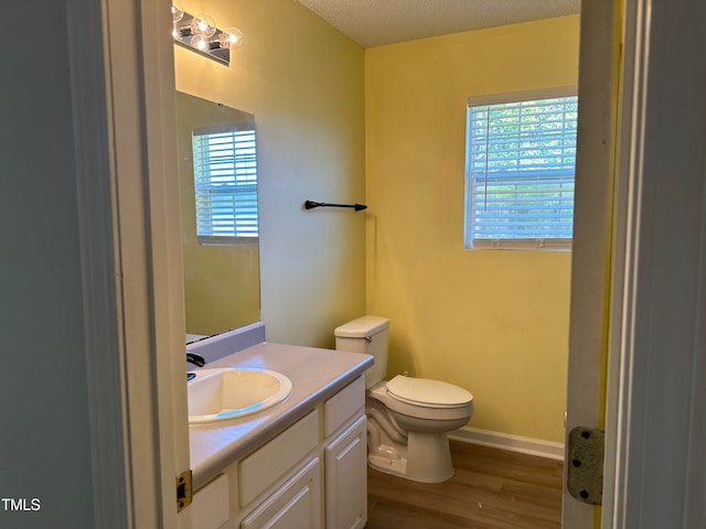 bathroom with vanity, a textured ceiling, wood-type flooring, and toilet