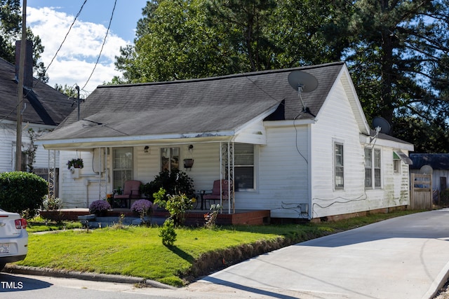 bungalow with a front yard and a porch