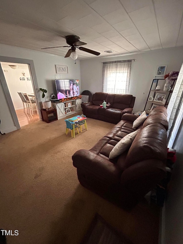 carpeted living room with ceiling fan