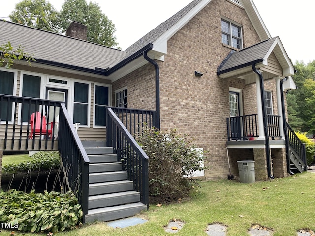 back of property featuring a wooden deck and a yard