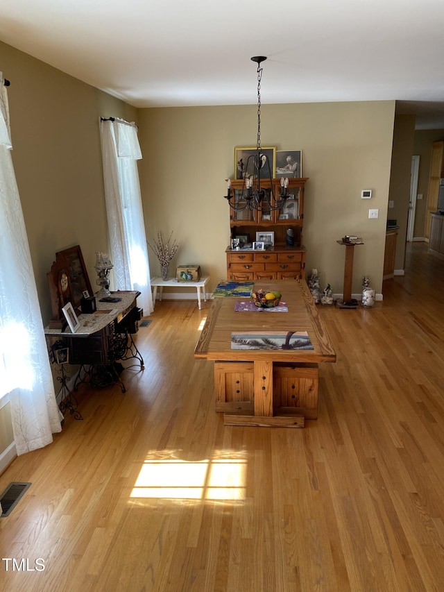 dining room with a notable chandelier and light wood-type flooring