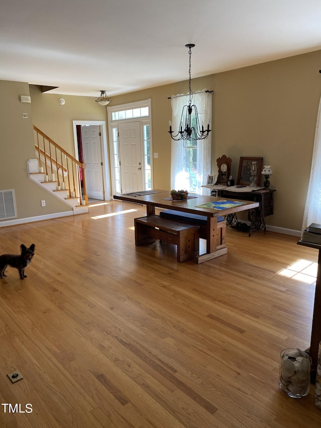 dining area featuring an inviting chandelier and light hardwood / wood-style floors