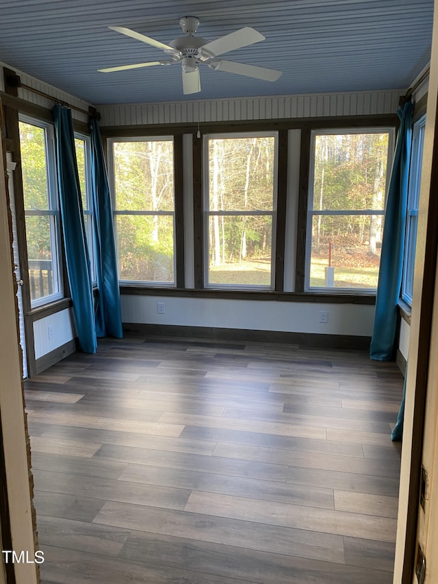 unfurnished sunroom featuring ceiling fan and plenty of natural light