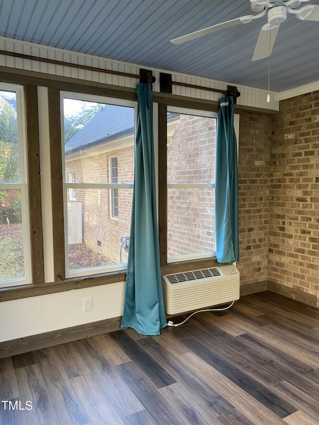 empty room with a wall mounted air conditioner, wooden ceiling, brick wall, hardwood / wood-style floors, and ceiling fan