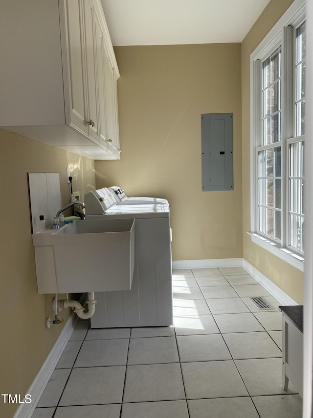 laundry room with light tile patterned floors, cabinets, electric panel, and plenty of natural light