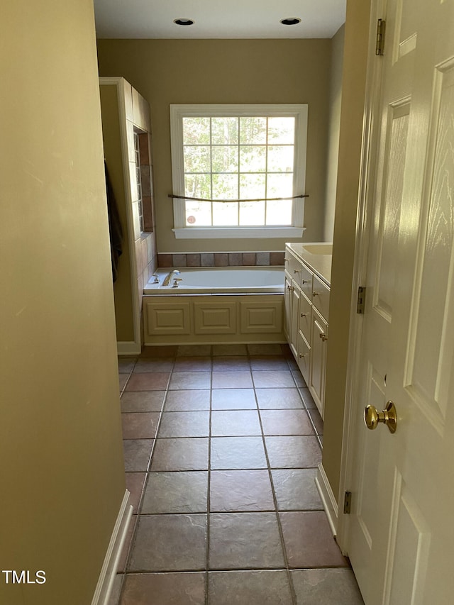 bathroom with vanity, a washtub, and tile patterned flooring