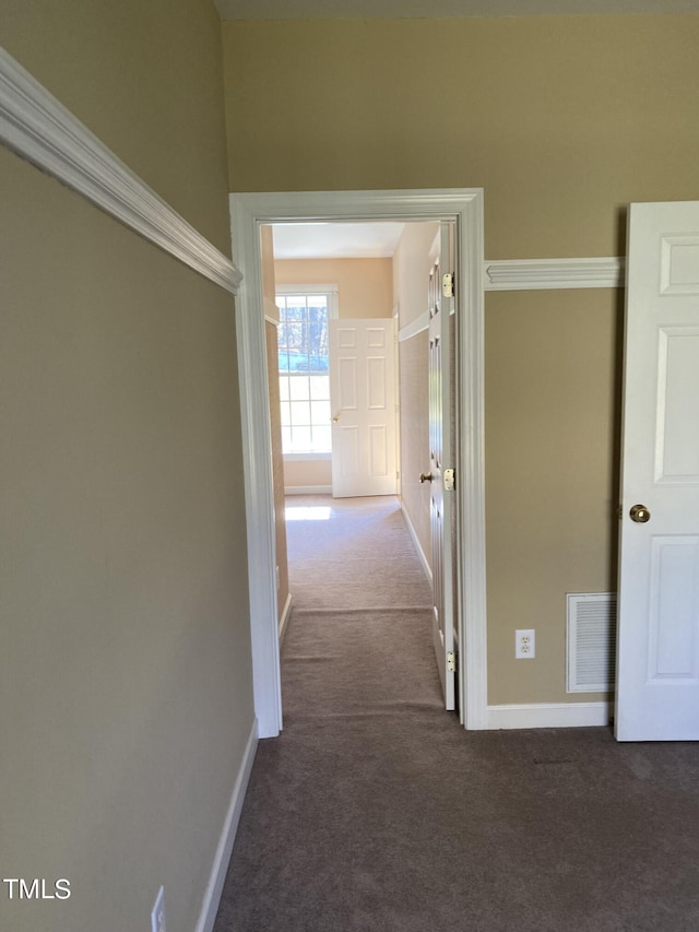 hallway with ornamental molding and carpet