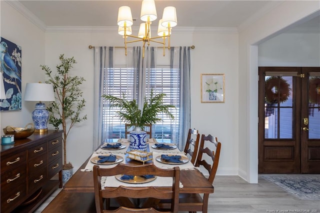 dining area with a notable chandelier, crown molding, and light hardwood / wood-style flooring