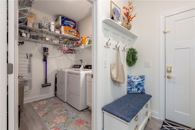 laundry area with washing machine and dryer and light hardwood / wood-style floors