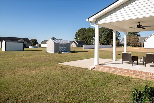 view of yard featuring a patio, ceiling fan, and a storage unit